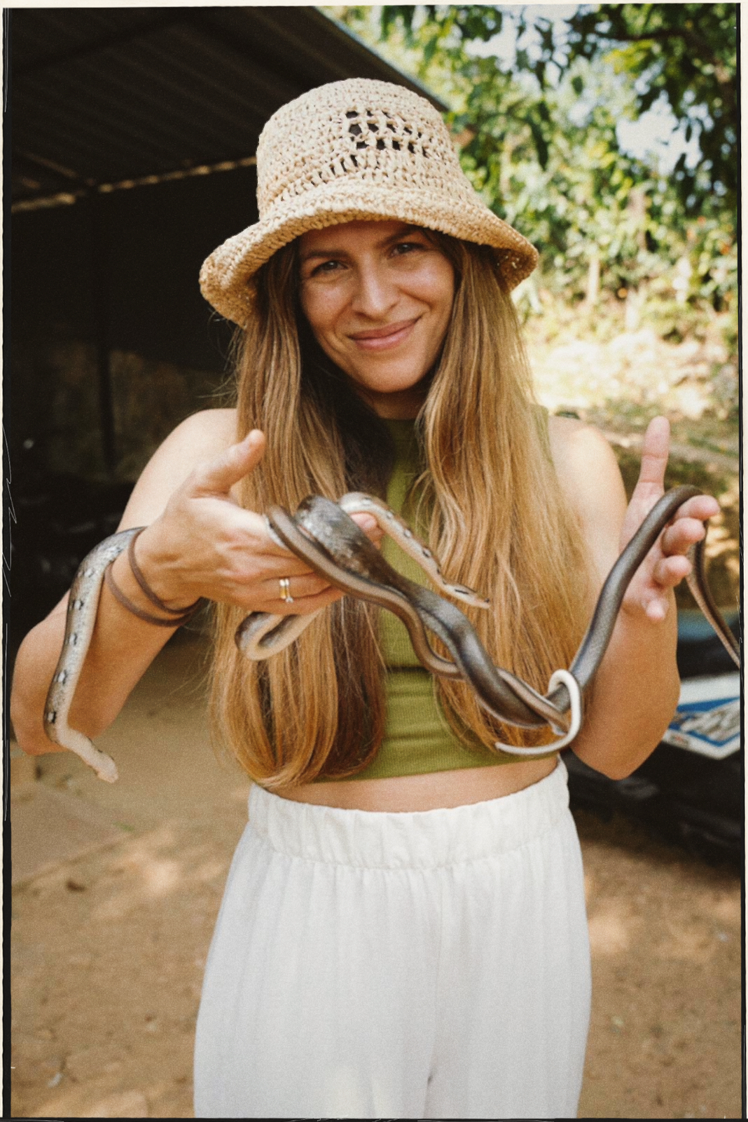 Traveler holding snakes and smiling
