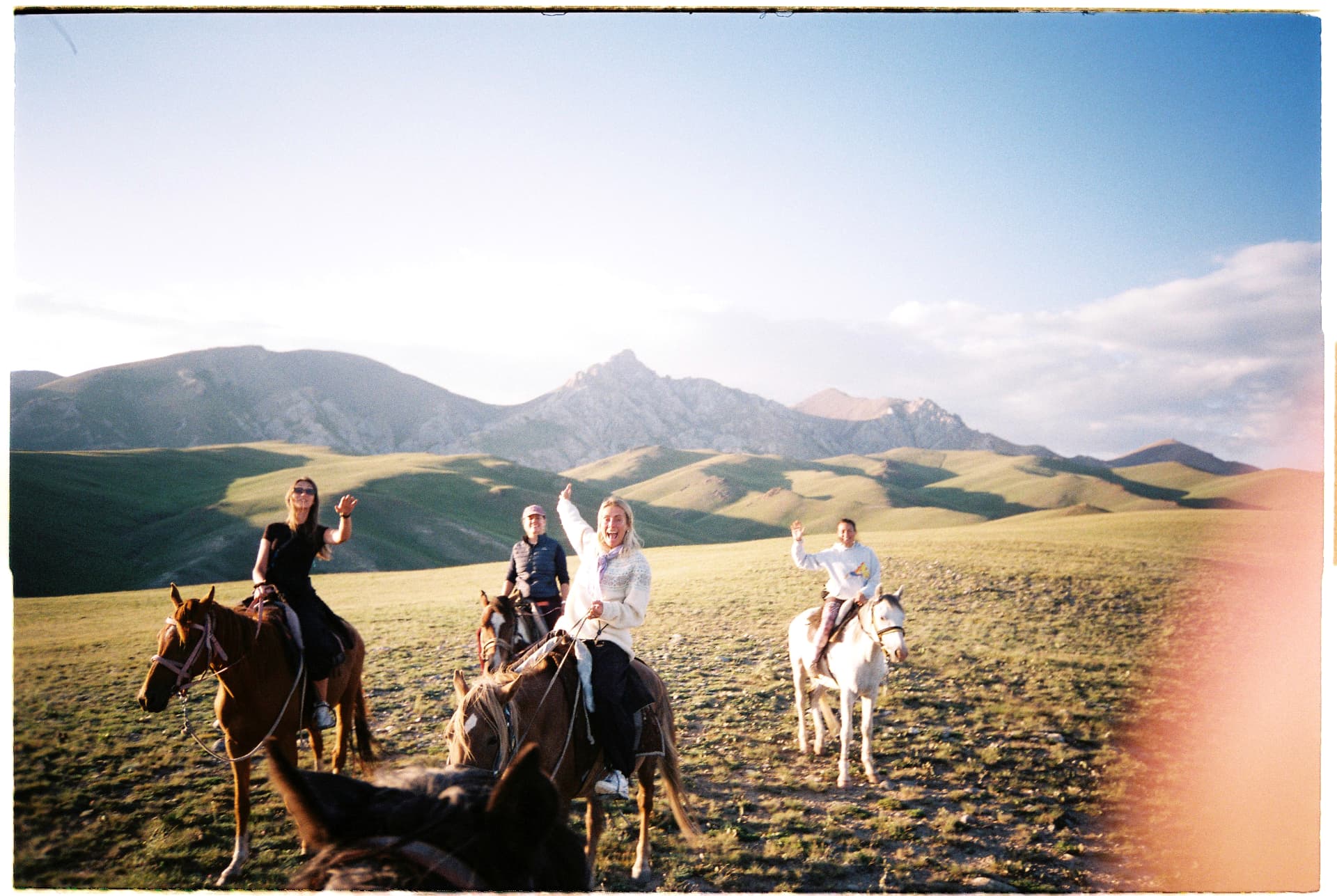 Riders waving on horseback, Kyrgyzstan