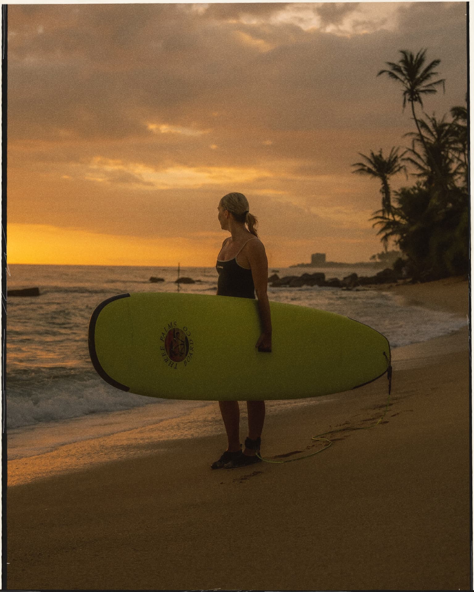 Surfer with a board watching the sunset